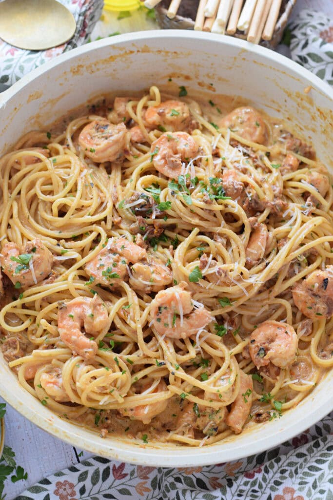 Shrimp pasta in a white skillet.