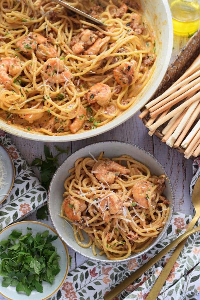 Sun dried tomato shrimp pasta in a white bowl.