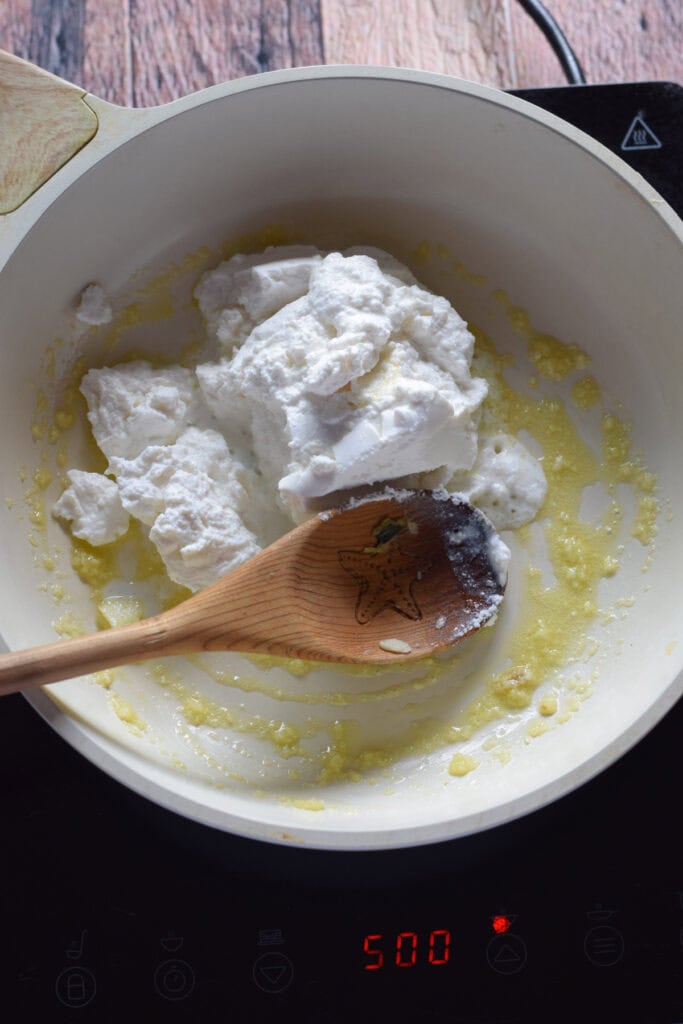 Adding ricotta to a skillet.
