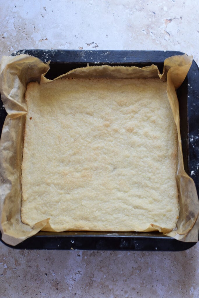 Baked cookie base in a baking dish.