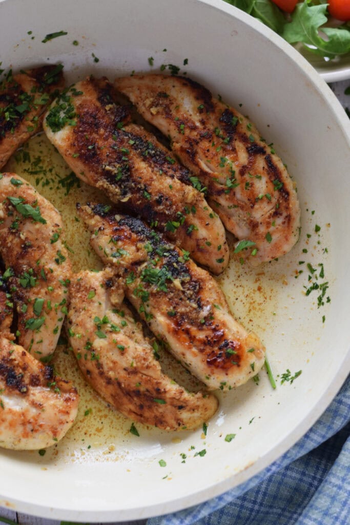 Close up of garlic butter chicken tenders in a skillet.