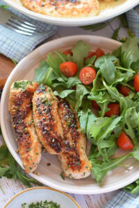Chicken tenders on a plate with a salad.