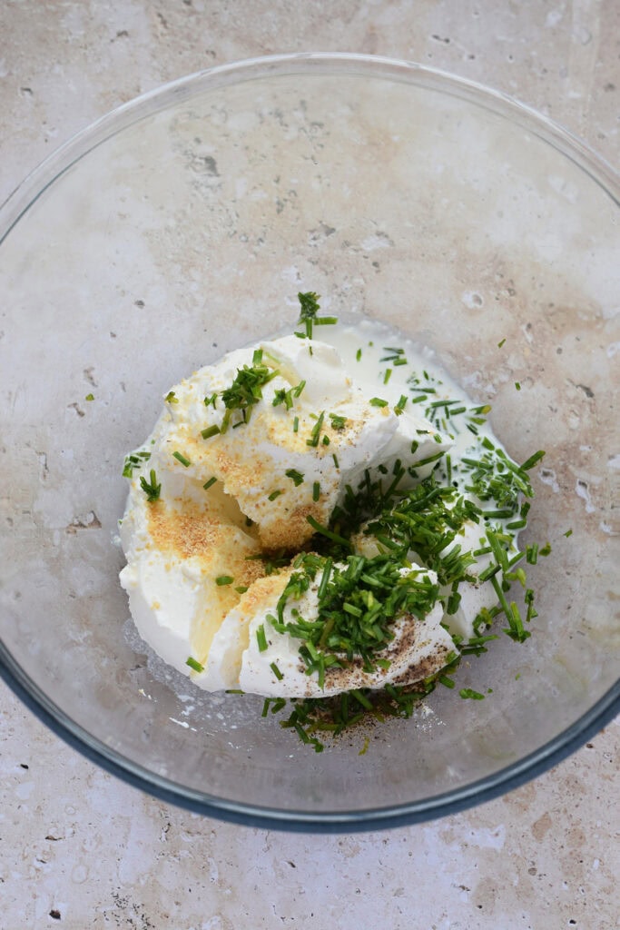 Making a mascarpone topping in a glass bowl.