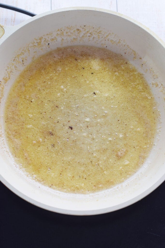 Cooking garlic butter in a skillet.