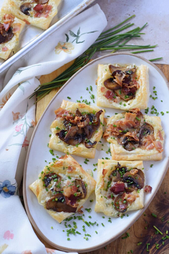 Mushroom puff pastry tarts on a white plate.