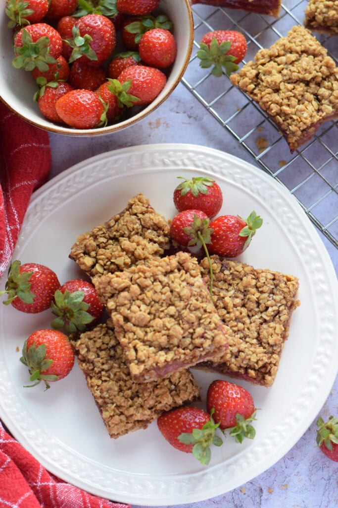 Strawberry crumble bars on a white plate.