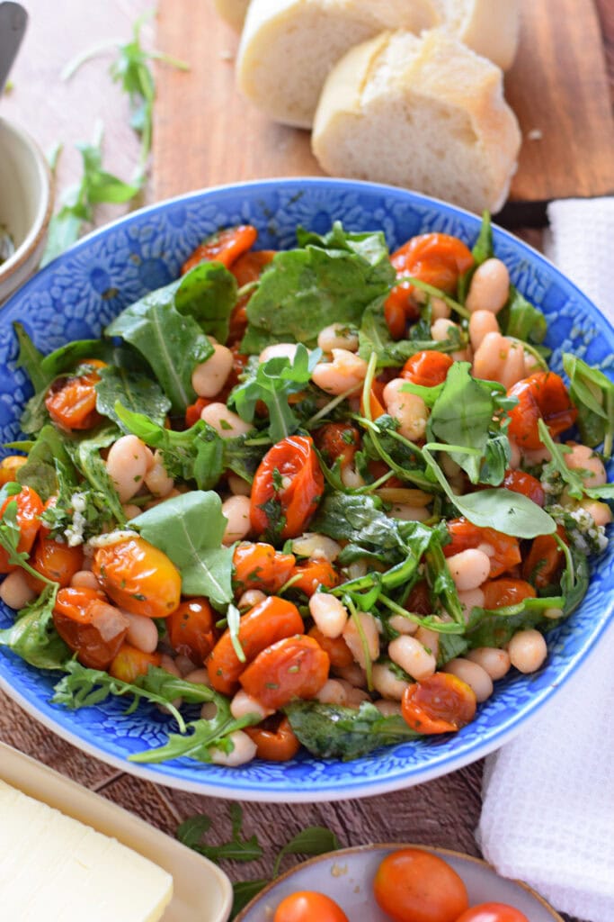 Bean and tomato salad in a blue bowl.