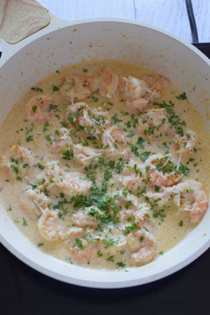 Creamy shrimp dish in a white skillet.