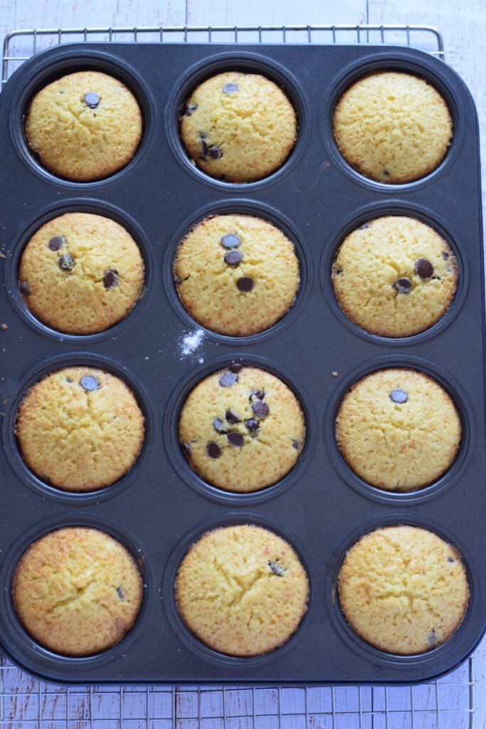 Baked chocolate chip orange muffins in a muffin tin.