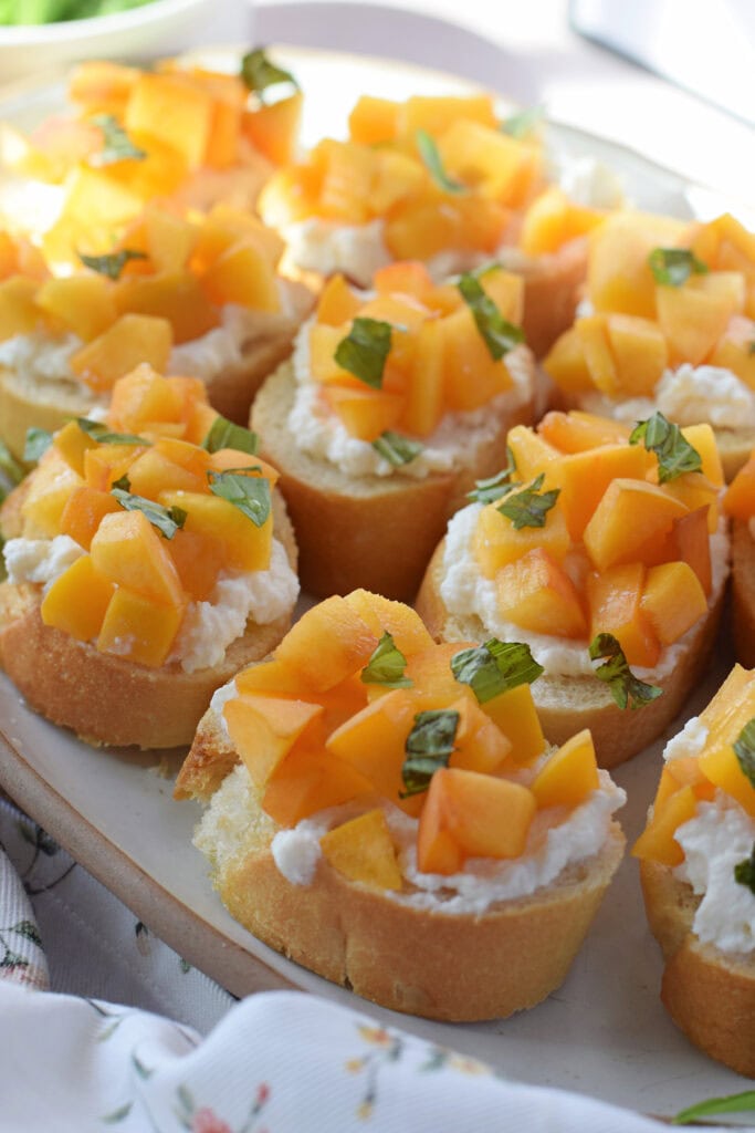 Peach crostini on a serving plate.