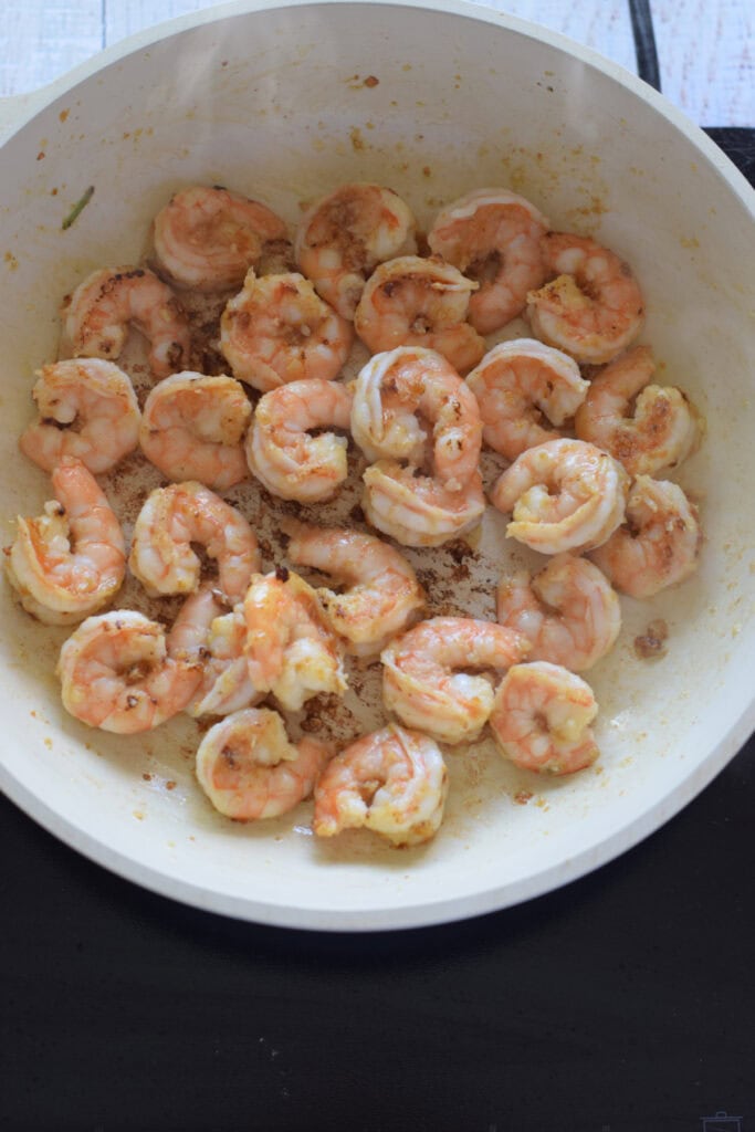 Cooked shrimp in a white skillet.
