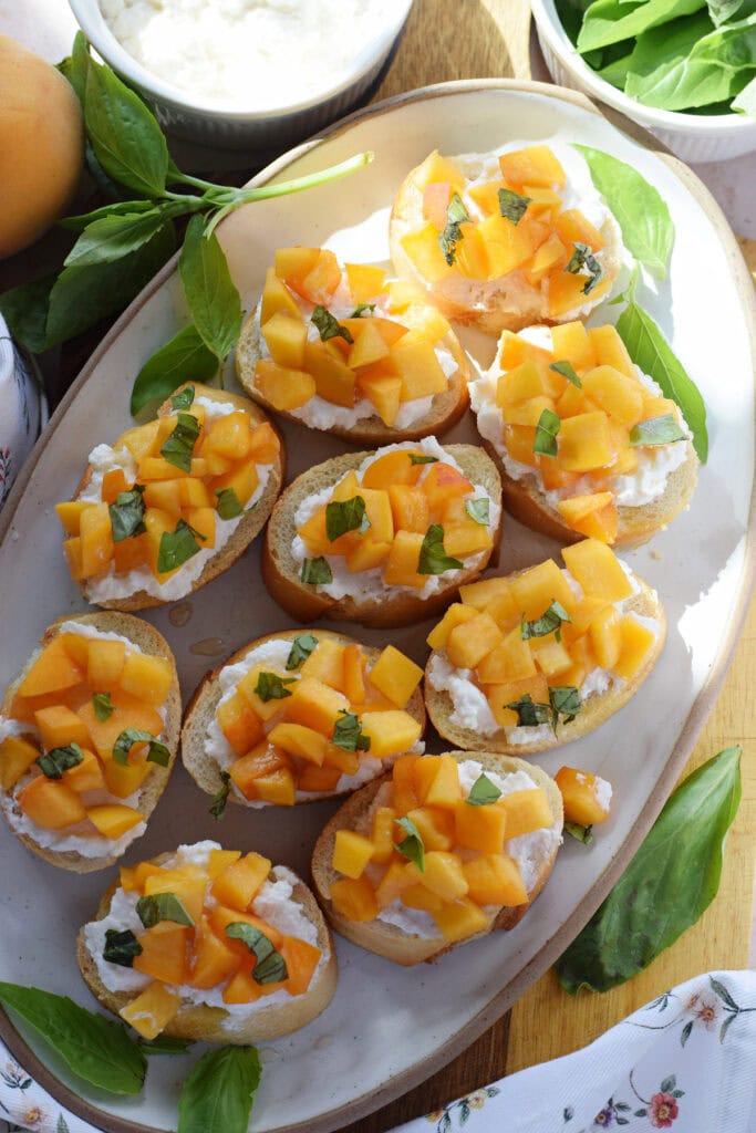 Peach crostini on a white tray.