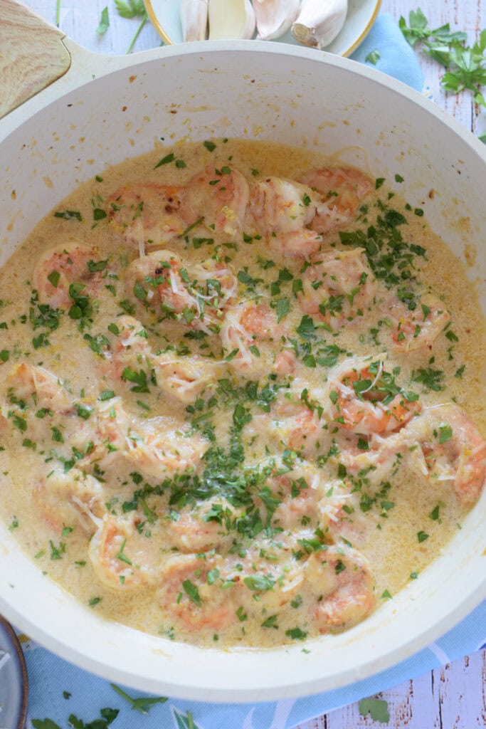Creamy garlic shrimp in a white skillet.