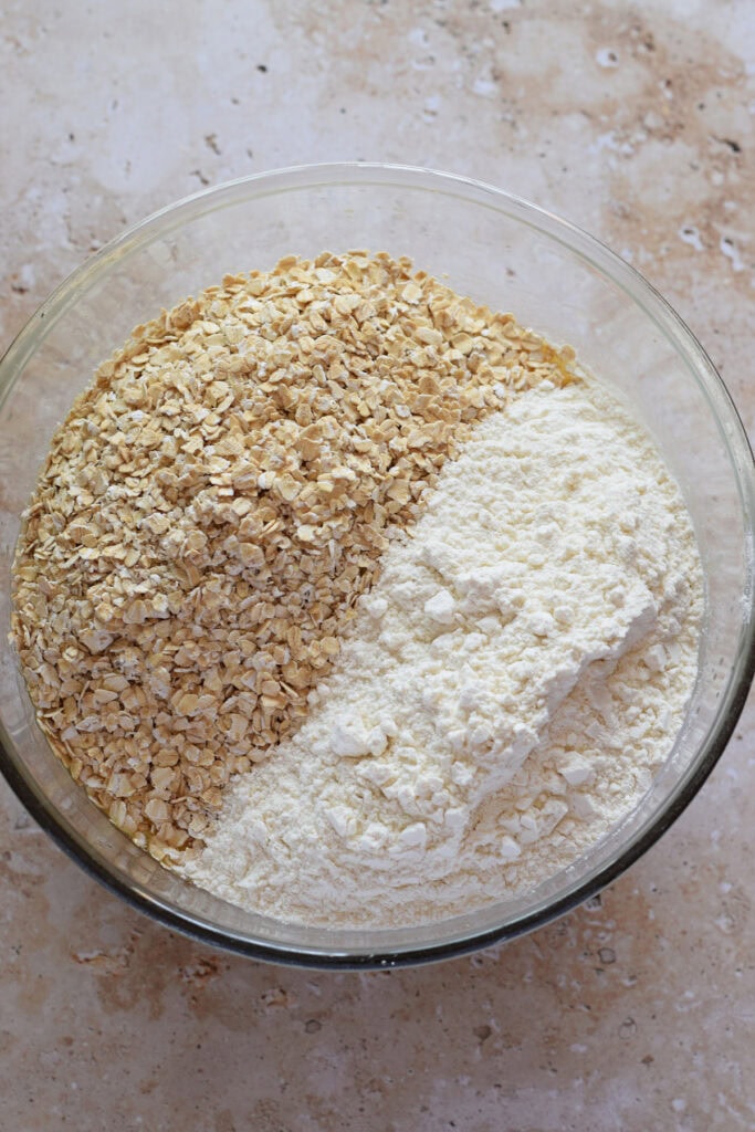 Adding flour and oats to cookie dough.
