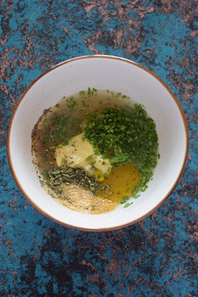 Making a marinade in a bowl for chicken tenders.