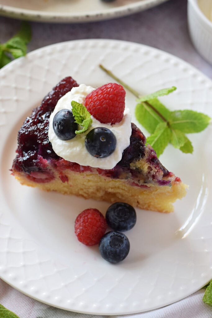 Upside down berry cake on a serving plate.