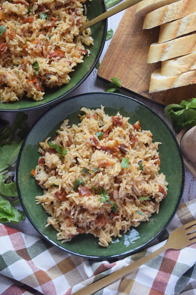 Sun dried tomato rice pilaf in a green bowl.