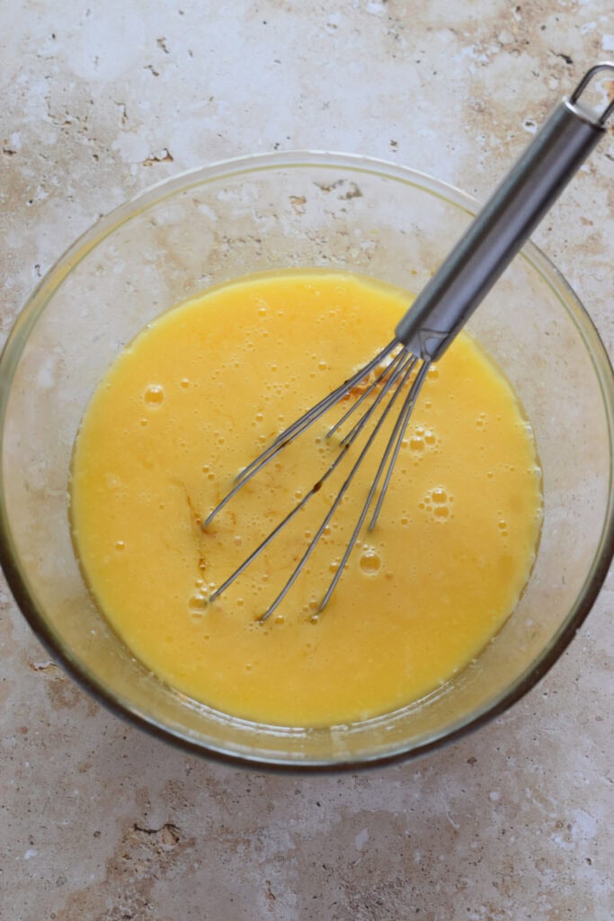 Whisked butter and eggs in a bowl.