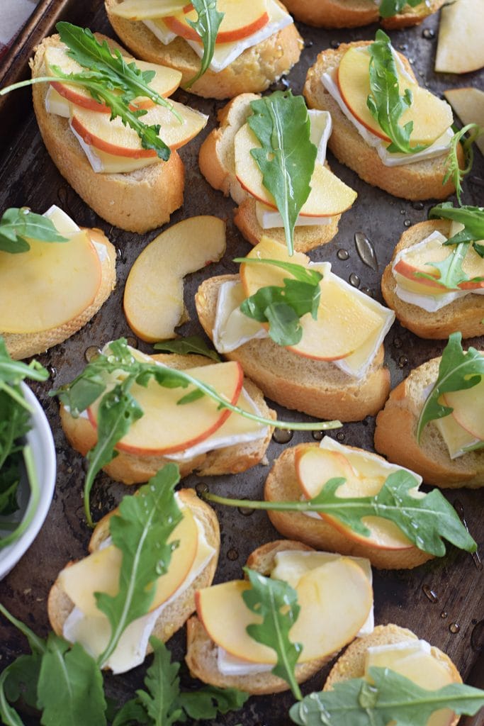 Apple and brie crostini on a tray.