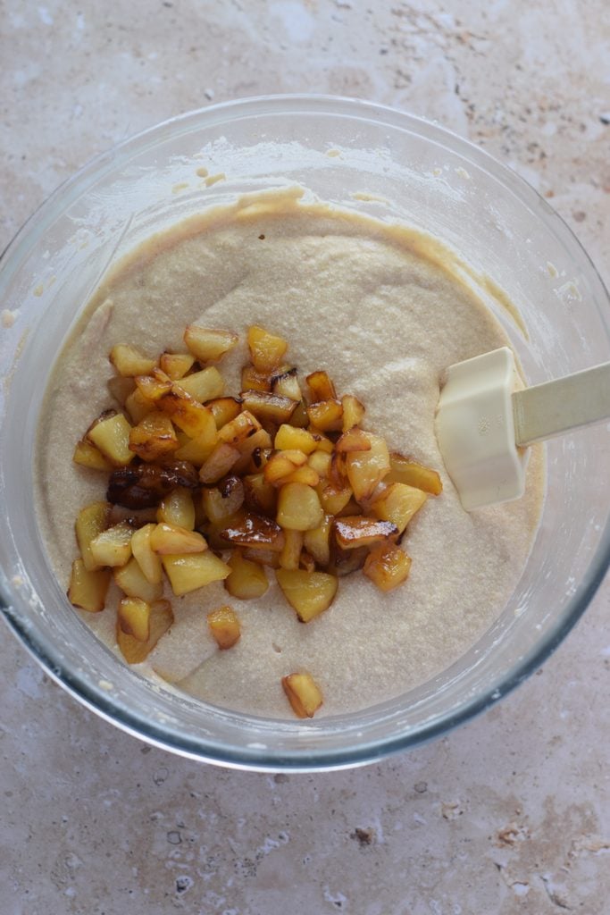 Adding apples to muffin batter.