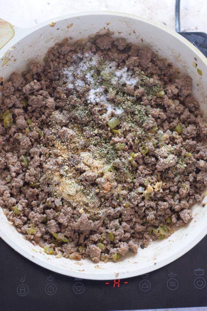 Cooked ground beef in a skillet with seasonings.
