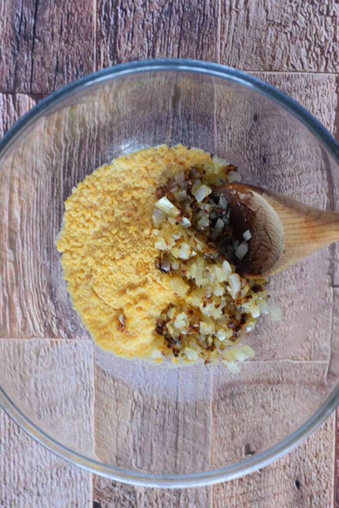 Bread crumbs, onions and milk in a bowl.