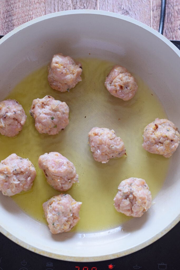 Cooking meatballs in a skillet.