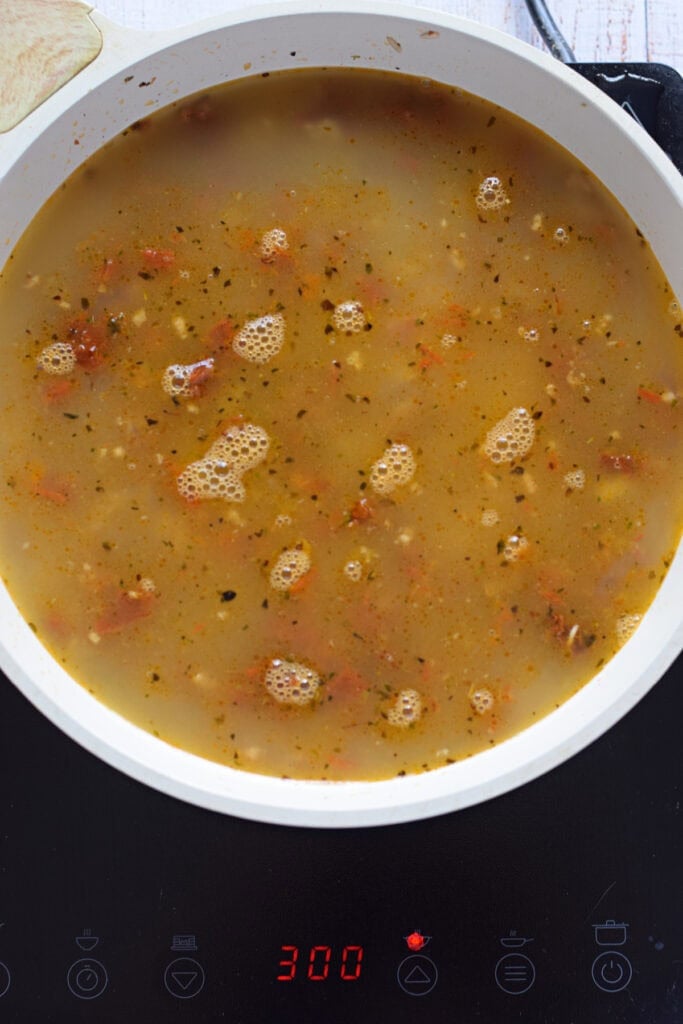 Adding vegetable broth to rice.