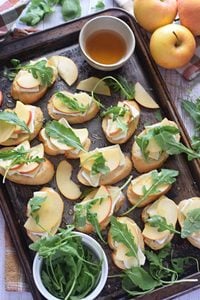 Apple and brie crostini on a baking tray.