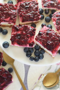 Berry cheesecake bars on a white plate.