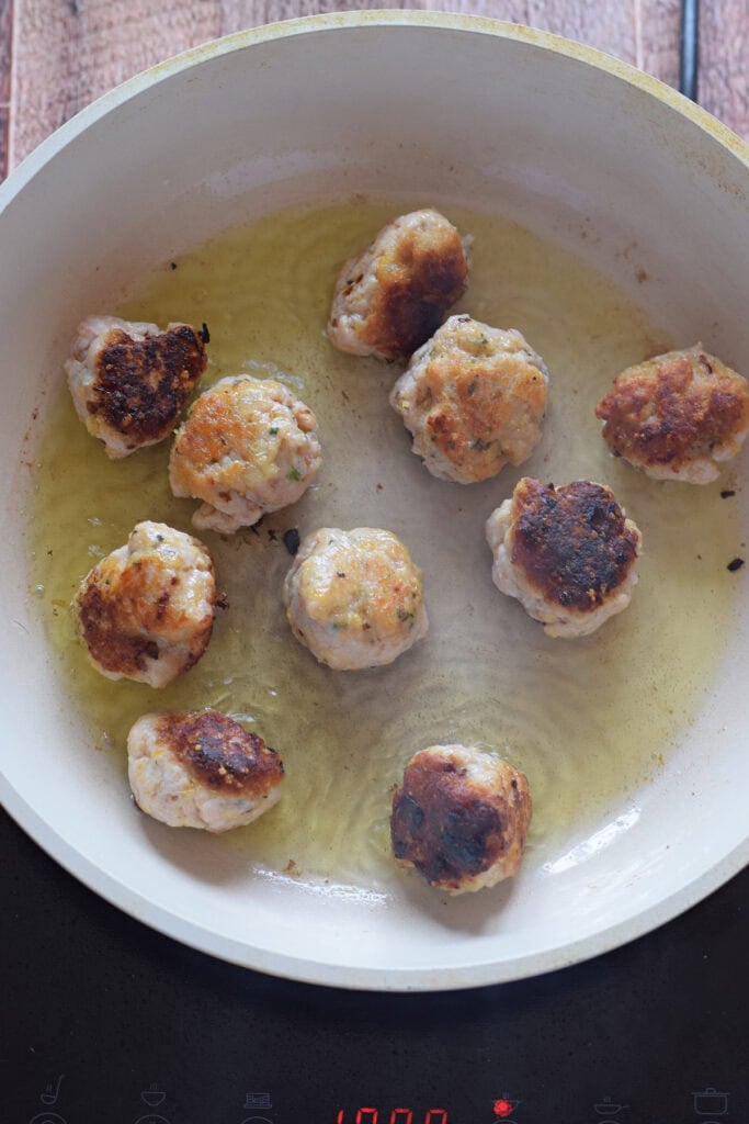 Cooking meatballs in a skillet.