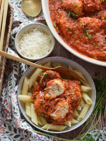 Meatballs in a tomato sauce with parmesan cheese.