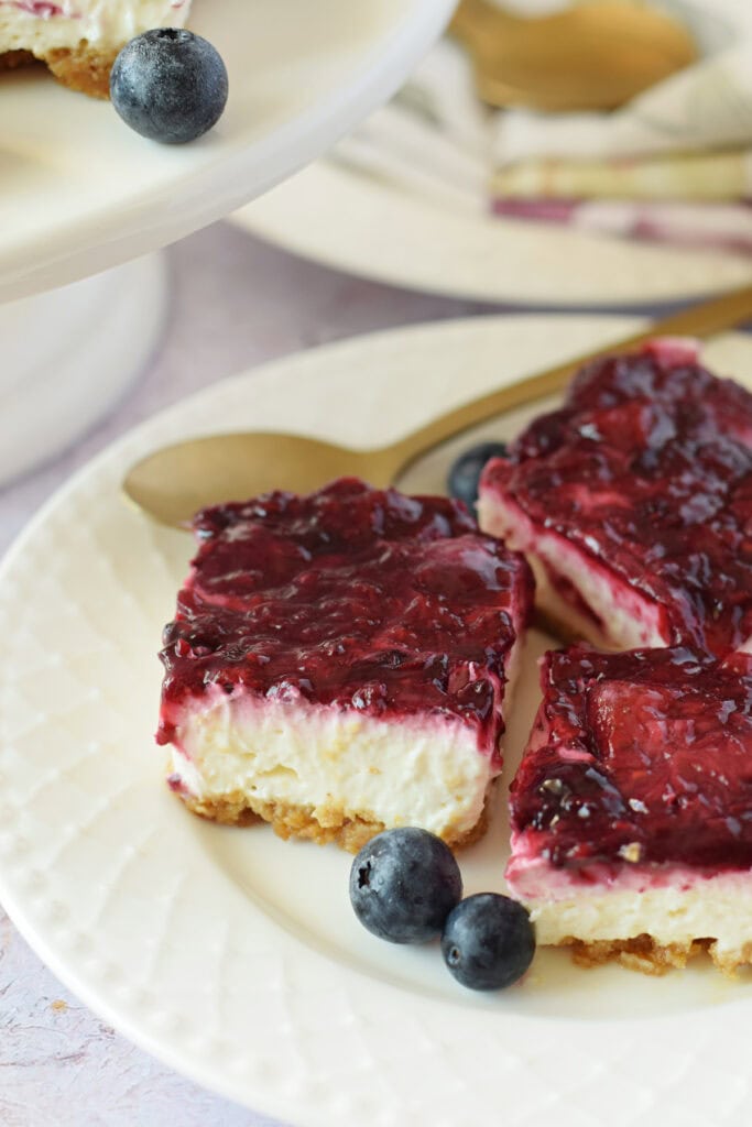 Close up of berry topped cheesecake bars.