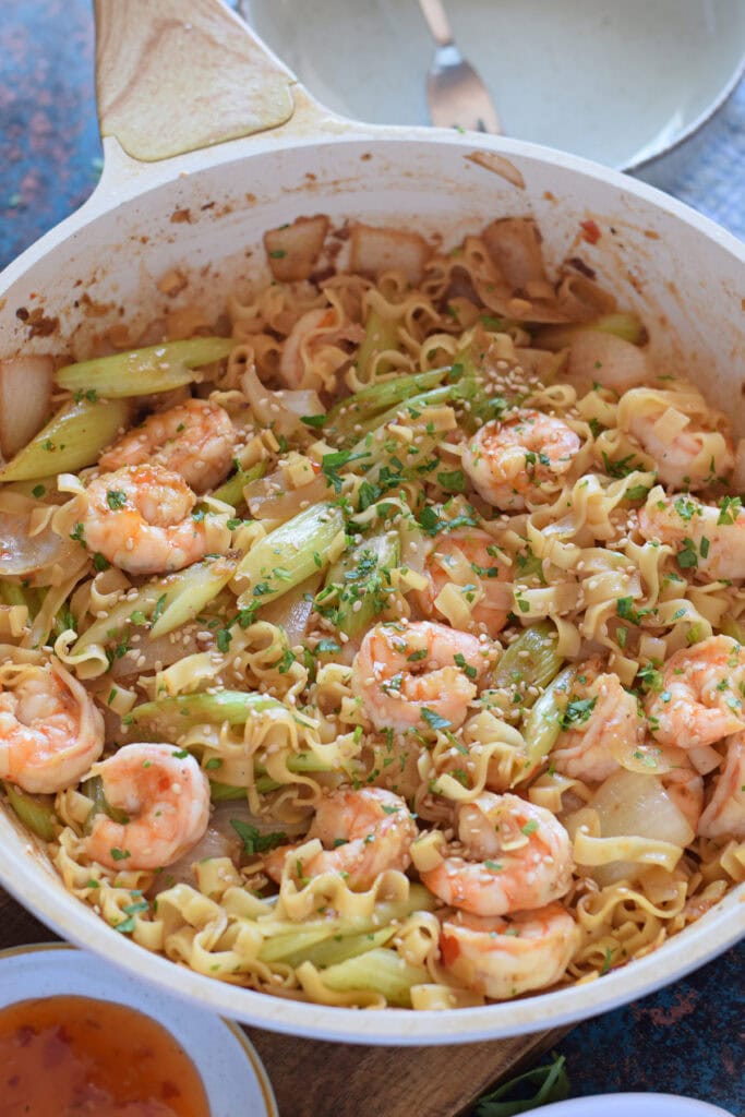 Shrimp and noodle stir fry in a skillet.