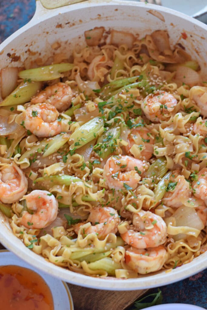 Shrimp stir fry with noodles in a skillet.