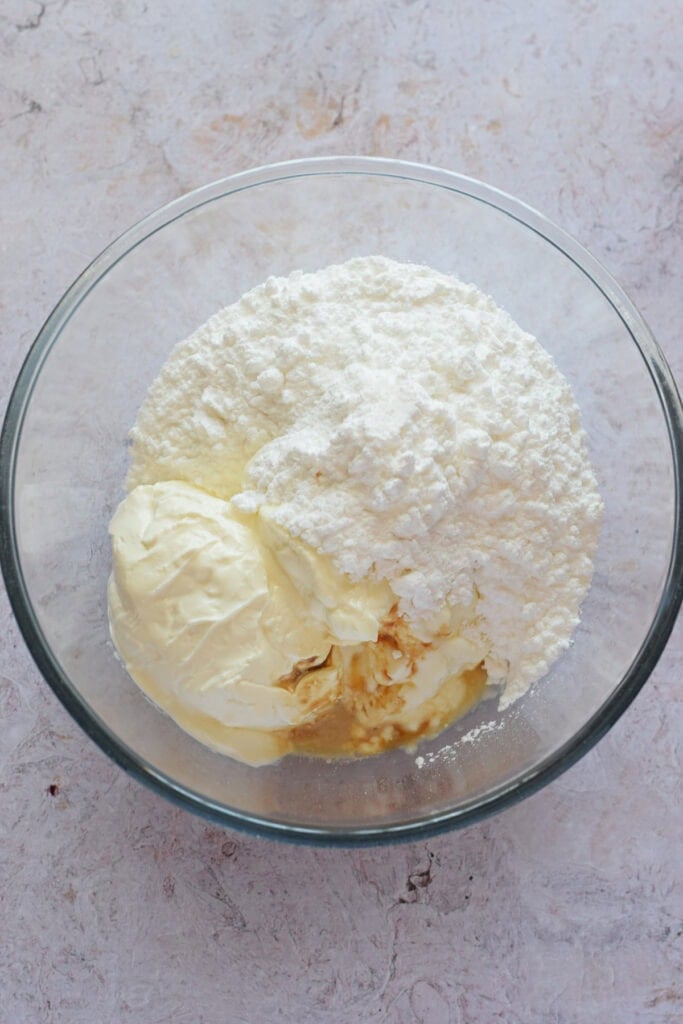 Making a cream cheese filling in a glass bowl.