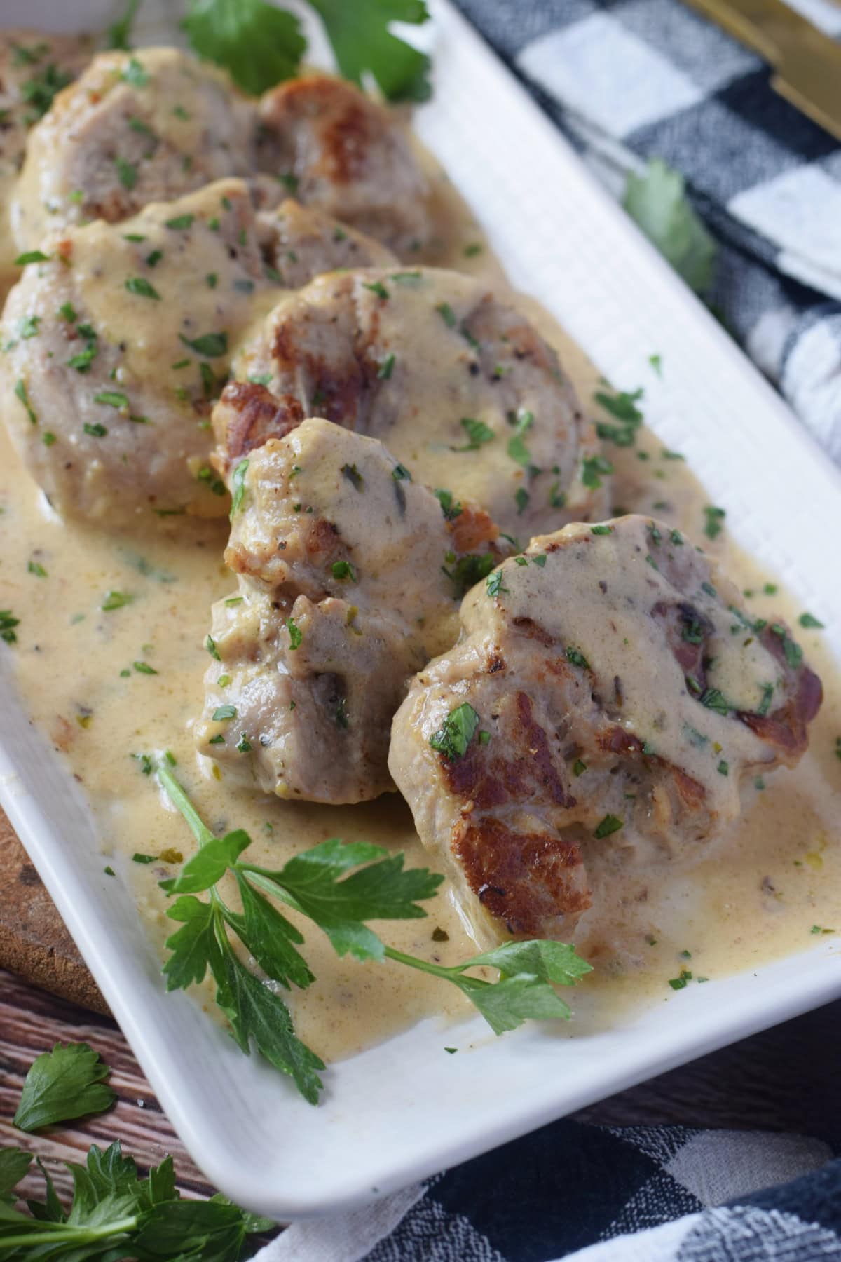 Pork in a cream sauce on a plate.