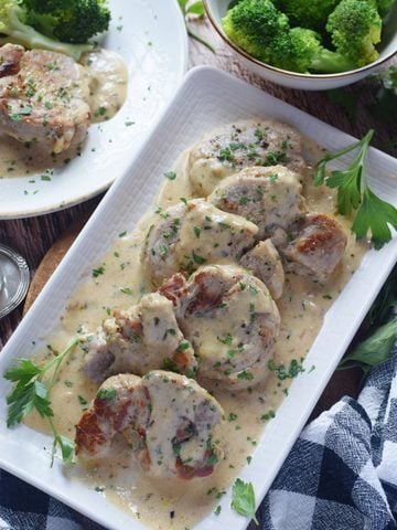 Pork on a white plate with sauce.