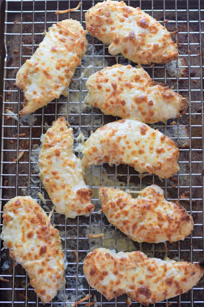 Mozzarella topped chicken on a tray.