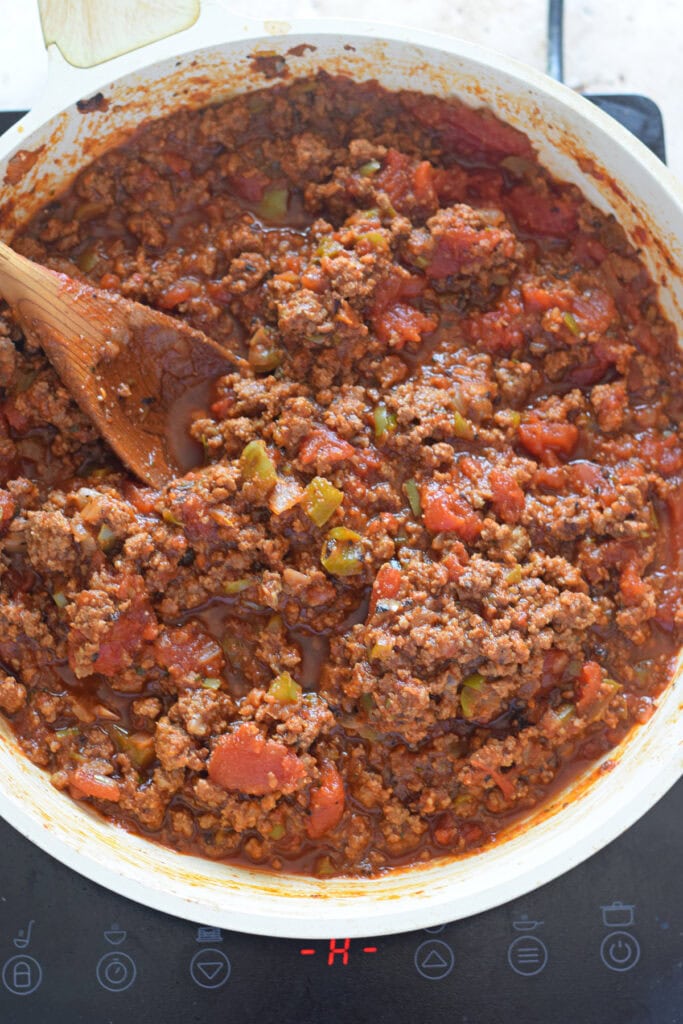 Beef and tomato sauce in a white skillet.