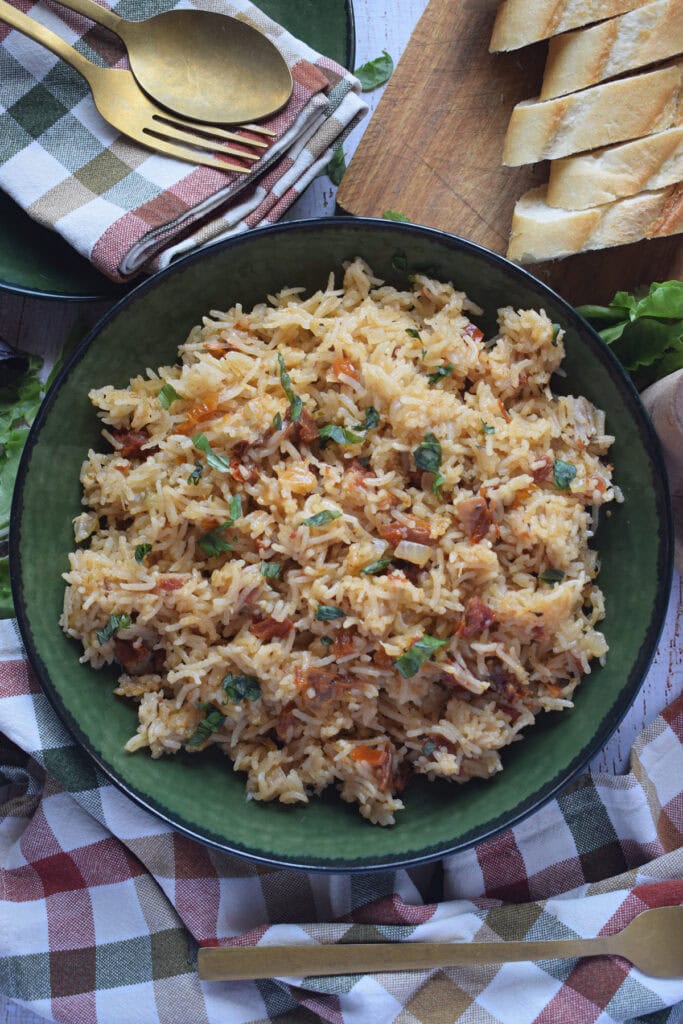 Sun dried tomato rice pilaf in a green bowl.