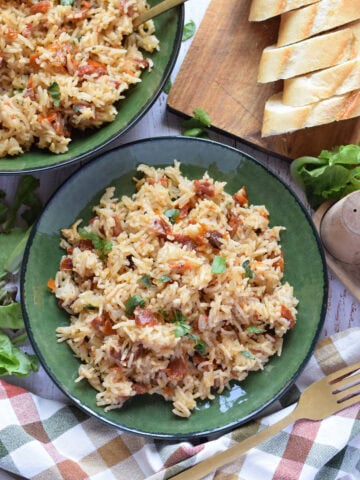Sun dried tomato rice pilaf in a green bowl.