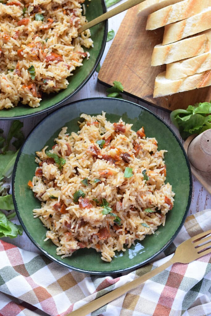 Sun dried tomato rice pilaf in a green bowl.