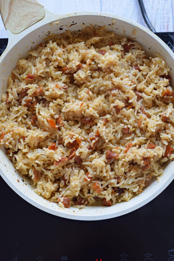 Rice pilaf with sun dried tomatoes in a skillet.