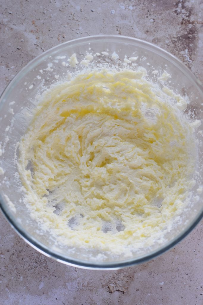 Whipped butter and sugar in a glass bowl.