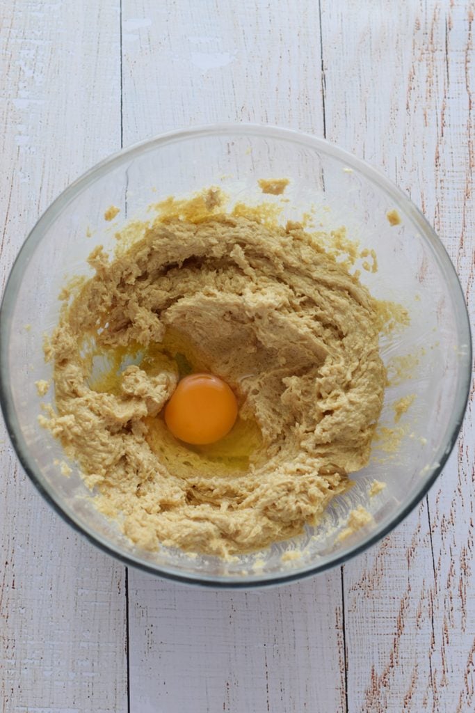 Adding eggs to cookie dough.