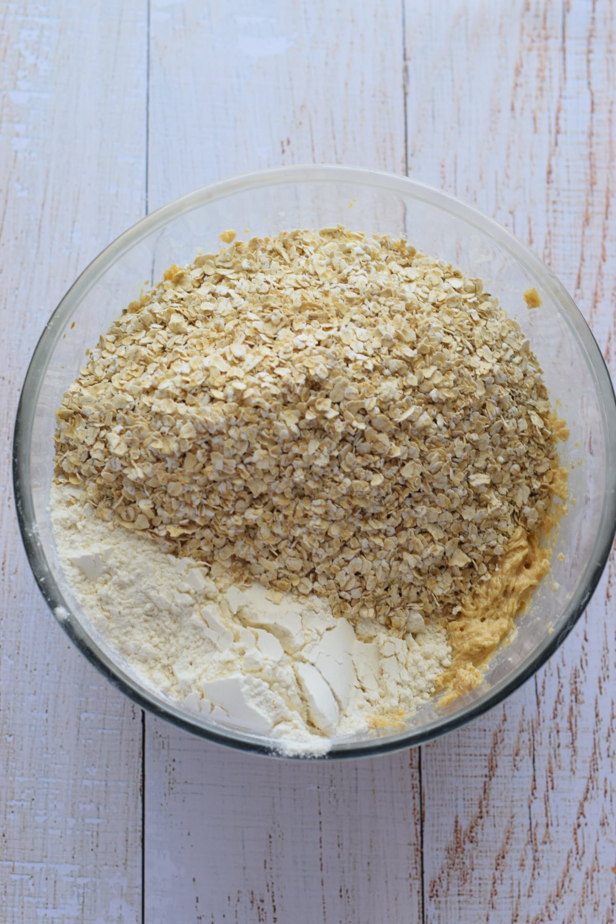 Adding oats and flour to cookie dough.