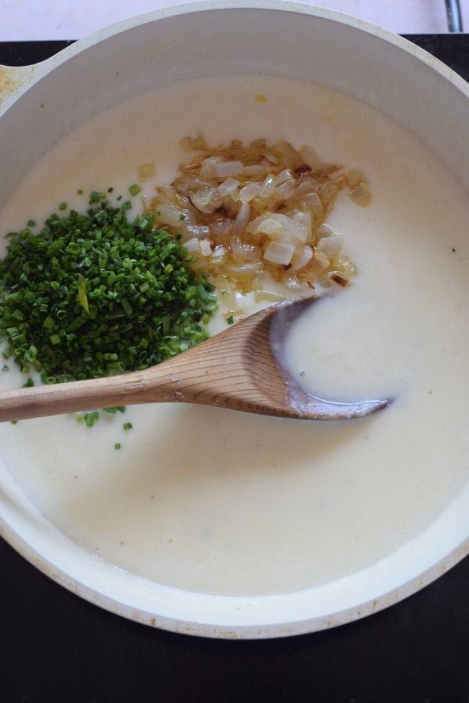 Adding onions and parsley to a sauce,.