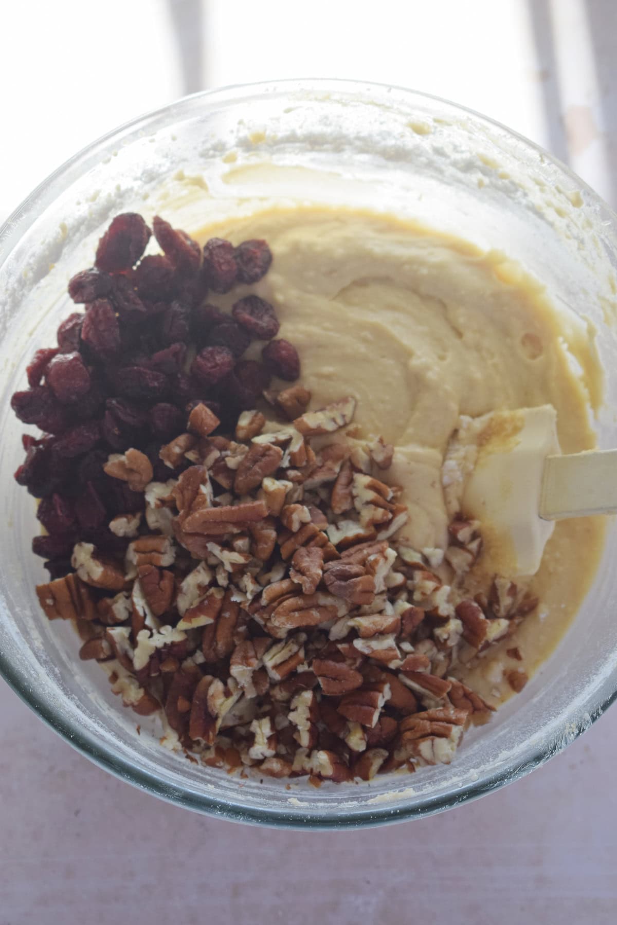Adding nuts and cranberries to muffin batter.
