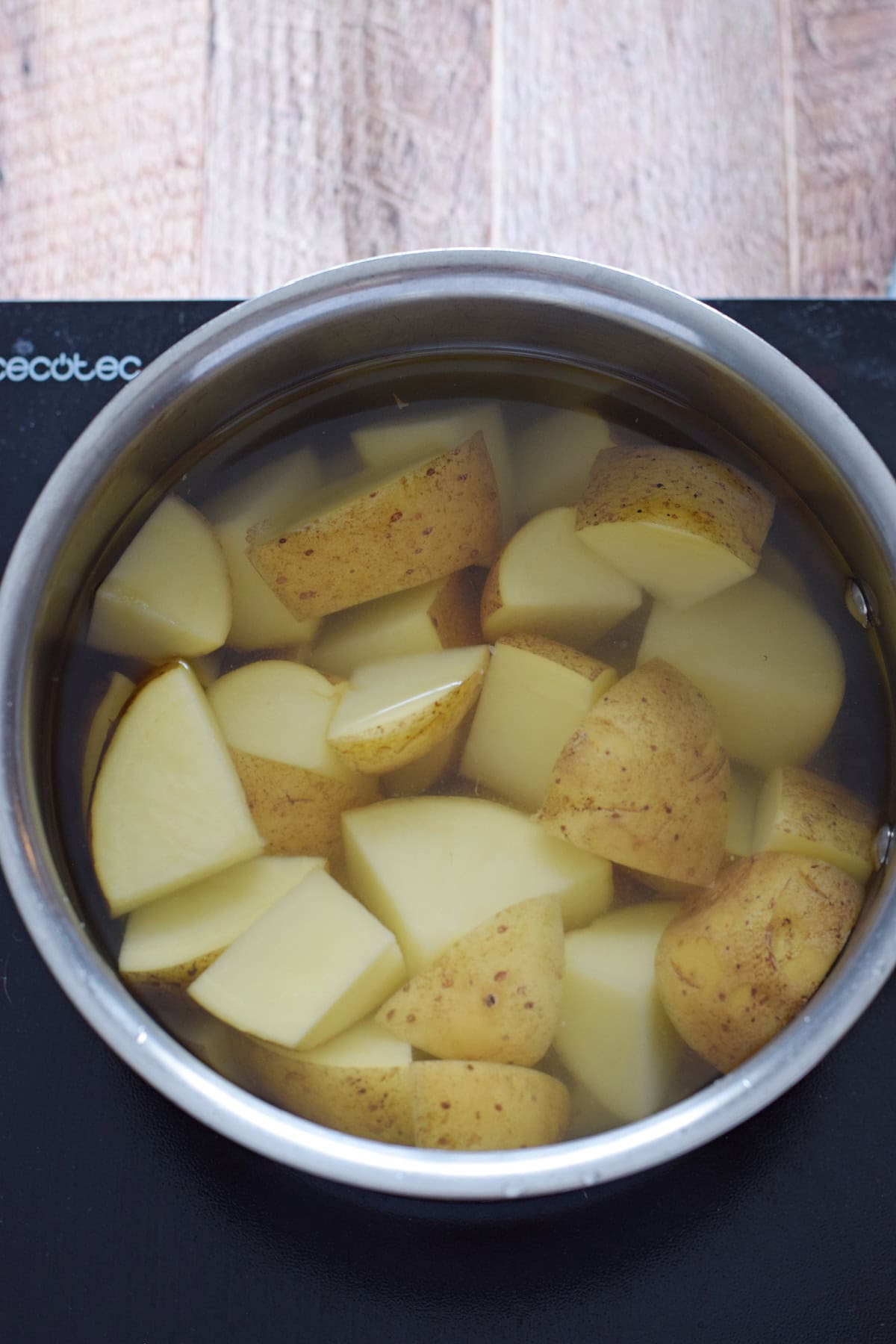 Parboiling potatoes in a saucepan.